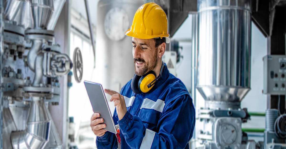 An engineer working with a tablet in an industrial setting