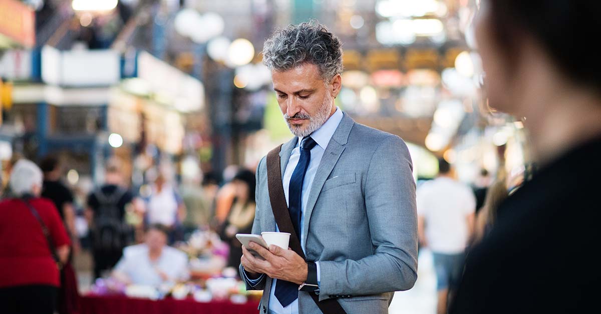 man using his cellphone for facility scheduling software