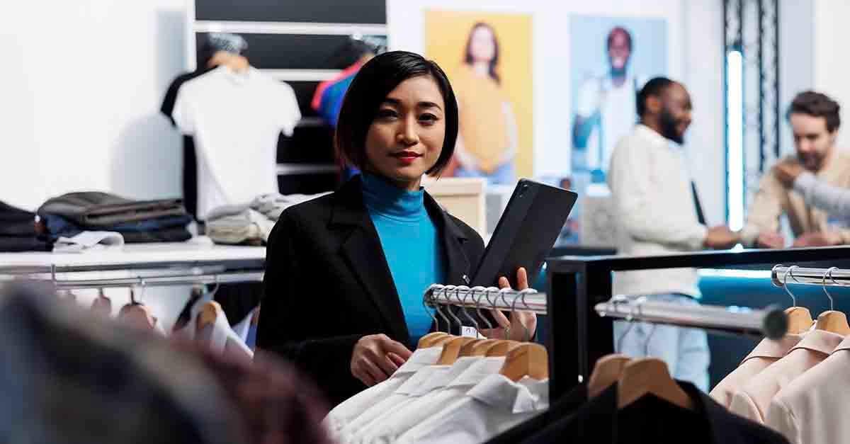 Person holding a tablet in a clothing store