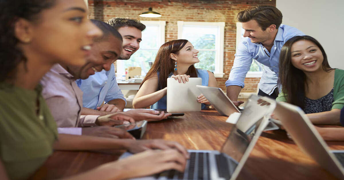 Group of young professionals laughing and working together